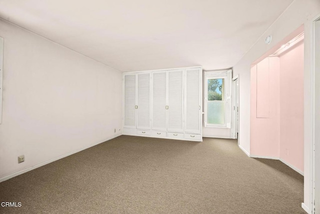 unfurnished bedroom featuring carpet flooring and baseboards