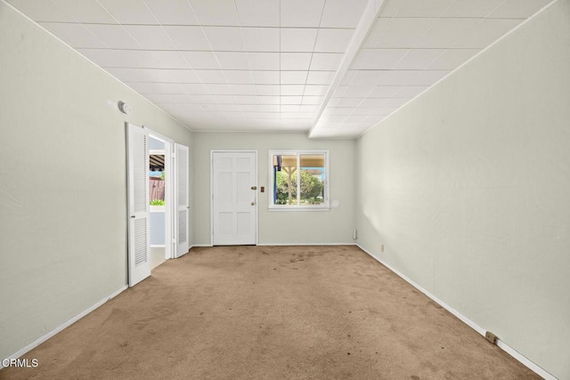 empty room featuring carpet flooring and baseboards