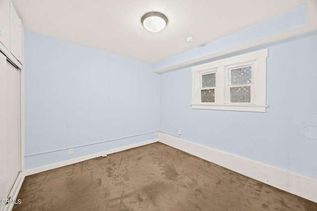 empty room featuring carpet flooring and baseboards