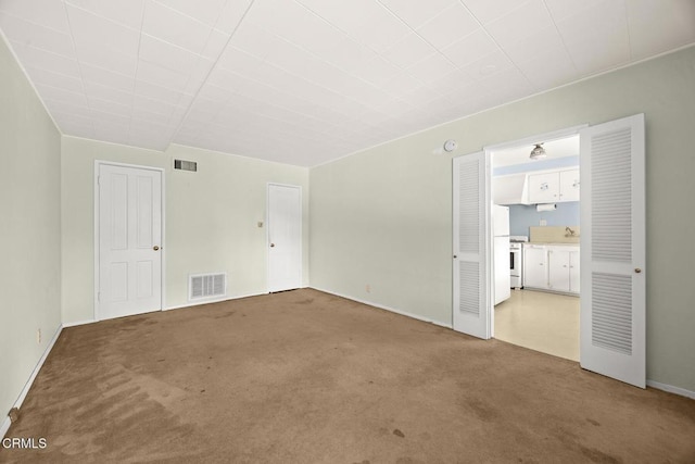 spare room featuring visible vents and carpet