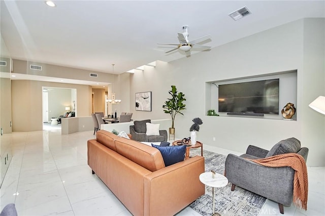 living area with ceiling fan with notable chandelier, visible vents, and marble finish floor