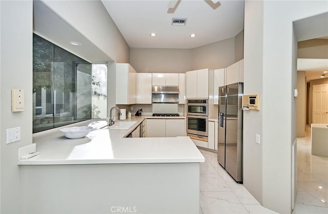 kitchen with visible vents, a sink, under cabinet range hood, appliances with stainless steel finishes, and marble finish floor