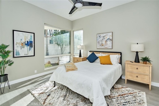 bedroom featuring a ceiling fan, baseboards, and wood finished floors