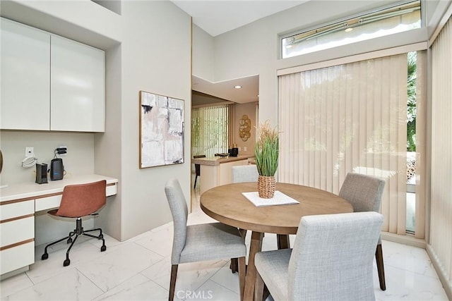 dining area with recessed lighting, baseboards, marble finish floor, and built in desk