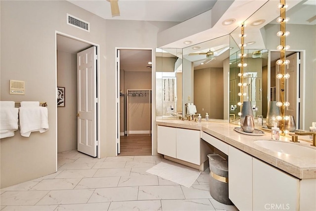 bathroom with a sink, visible vents, marble finish floor, and double vanity