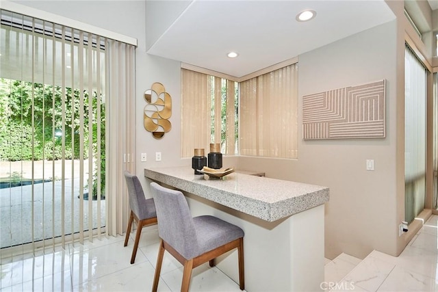 dining space with recessed lighting and marble finish floor