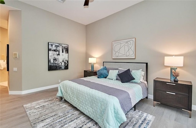 bedroom with a ceiling fan, baseboards, and light wood-type flooring