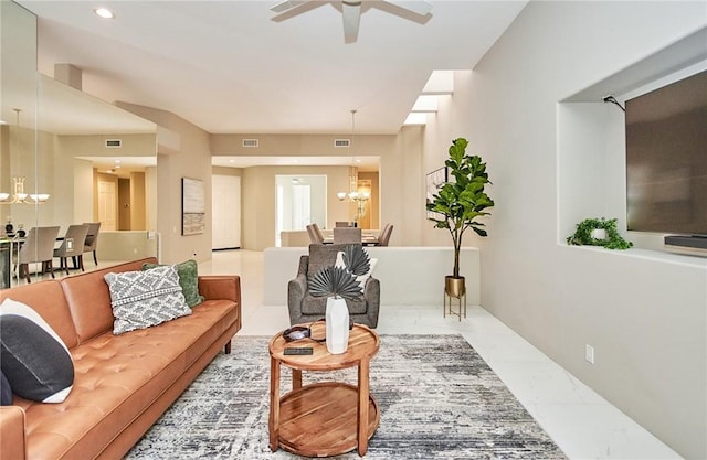 living area featuring recessed lighting, visible vents, marble finish floor, and ceiling fan with notable chandelier