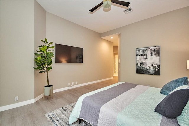 bedroom featuring visible vents, baseboards, wood finished floors, and a ceiling fan