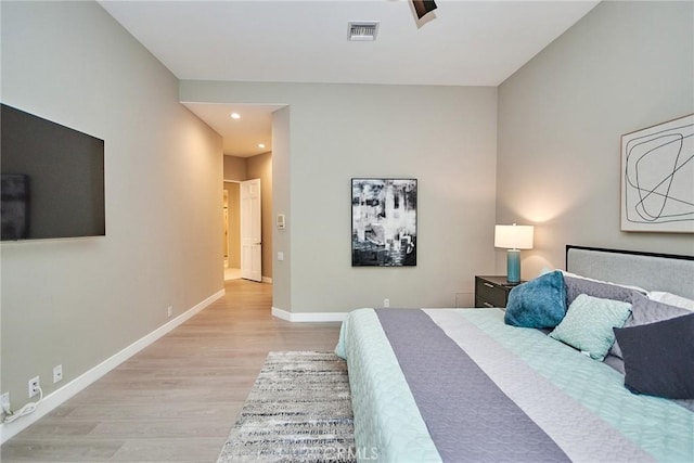 bedroom with visible vents, light wood-style floors, and baseboards