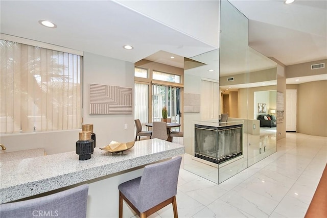 kitchen with recessed lighting, visible vents, and marble finish floor