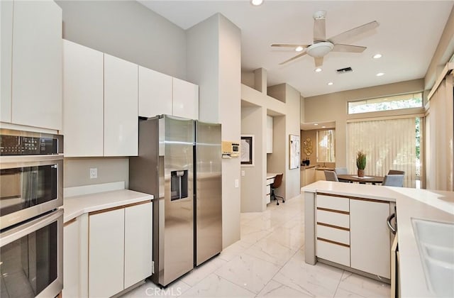 kitchen featuring white cabinetry, light countertops, marble finish floor, and stainless steel appliances