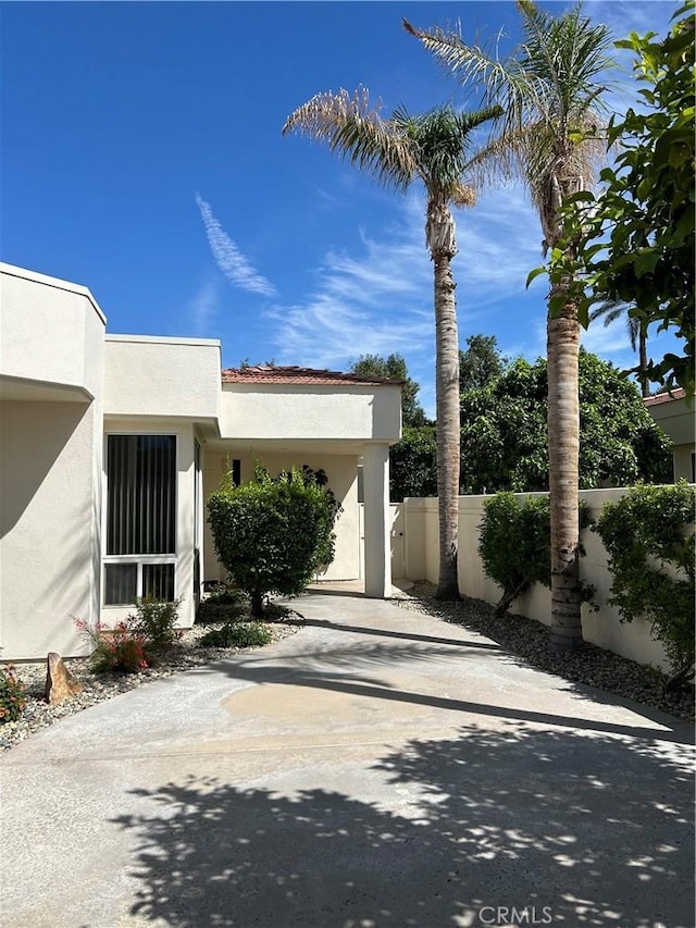 exterior space featuring stucco siding and fence