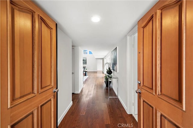 hall featuring baseboards and dark wood-style flooring