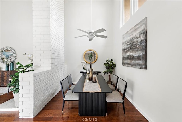 dining room with baseboards, a high ceiling, ceiling fan, and wood finished floors