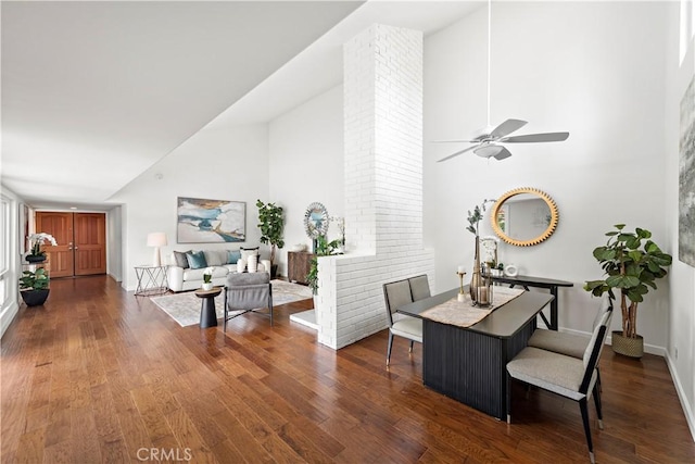 dining area featuring ceiling fan, wood finished floors, baseboards, and high vaulted ceiling