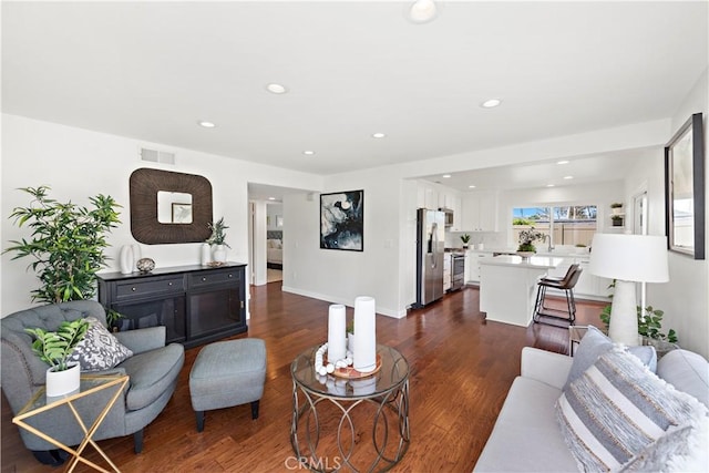 living room featuring dark wood finished floors, visible vents, recessed lighting, and baseboards