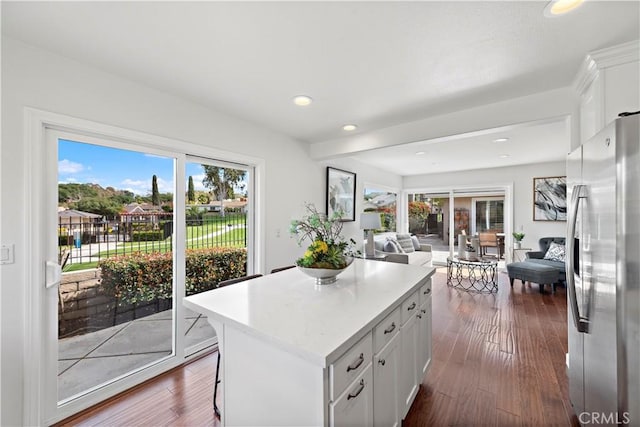 kitchen with dark wood-style floors, open floor plan, freestanding refrigerator, and a center island