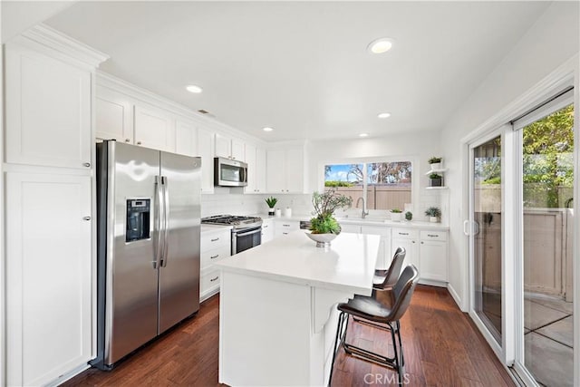 kitchen featuring a wealth of natural light, a center island, stainless steel appliances, and a sink