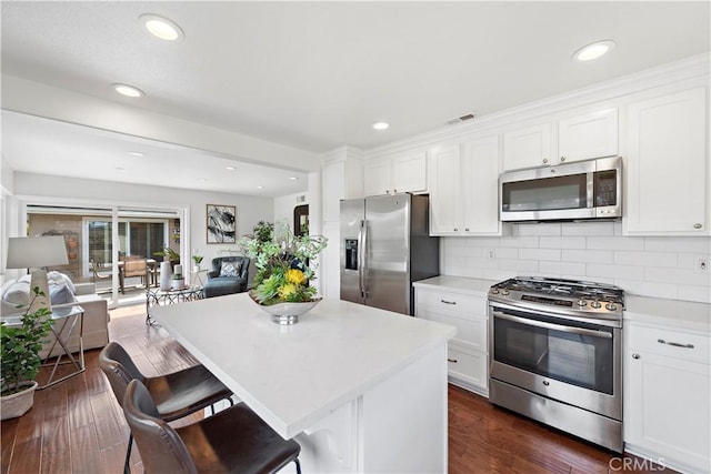 kitchen featuring visible vents, light countertops, appliances with stainless steel finishes, white cabinetry, and open floor plan