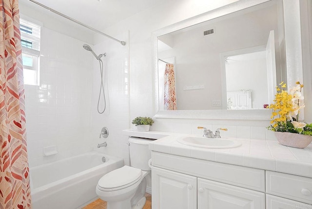 full bath featuring shower / bath combo with shower curtain, toilet, vanity, and visible vents