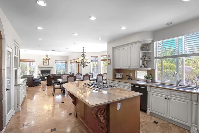 kitchen with recessed lighting, dishwasher, a sink, stainless steel gas cooktop, and a chandelier
