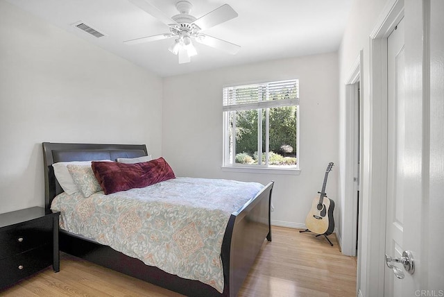 bedroom with visible vents, light wood finished floors, baseboards, and a ceiling fan