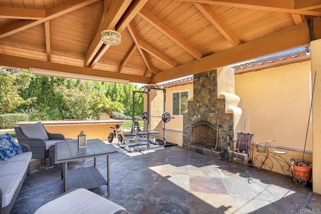 view of patio featuring a gazebo and an outdoor living space with a fireplace