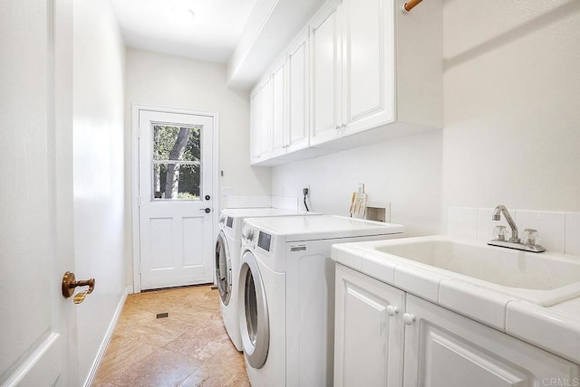 laundry room featuring baseboards, a sink, independent washer and dryer, and cabinet space