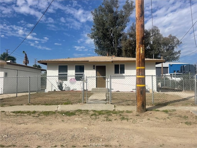 view of front of property featuring stucco siding, a fenced front yard, and a gate