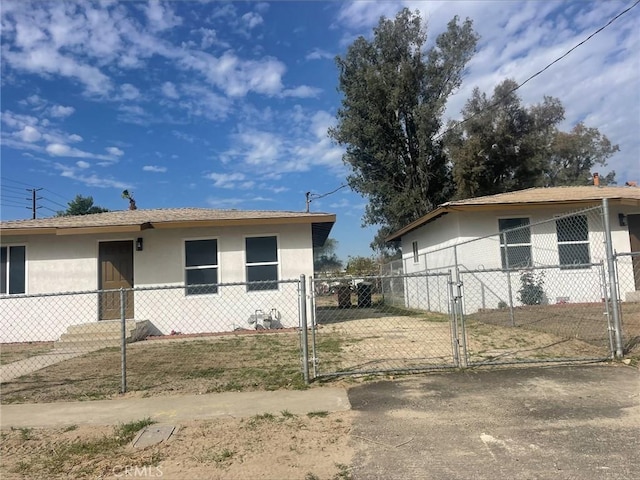 view of side of home featuring stucco siding, fence, and a gate