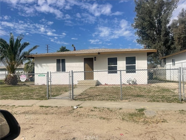 view of front facade with a gate, stucco siding, and fence