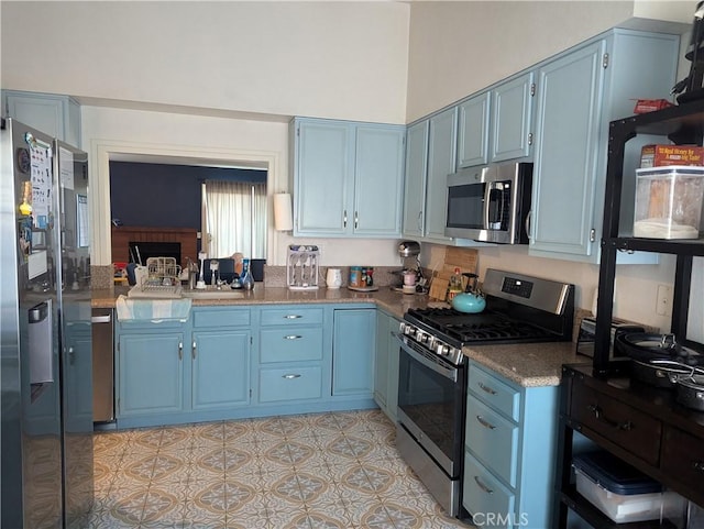 kitchen featuring dark countertops, blue cabinetry, and stainless steel appliances