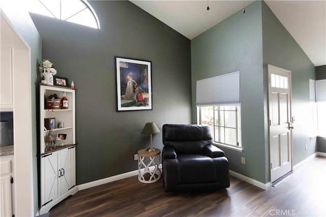 sitting room with lofted ceiling, baseboards, and dark wood-style flooring