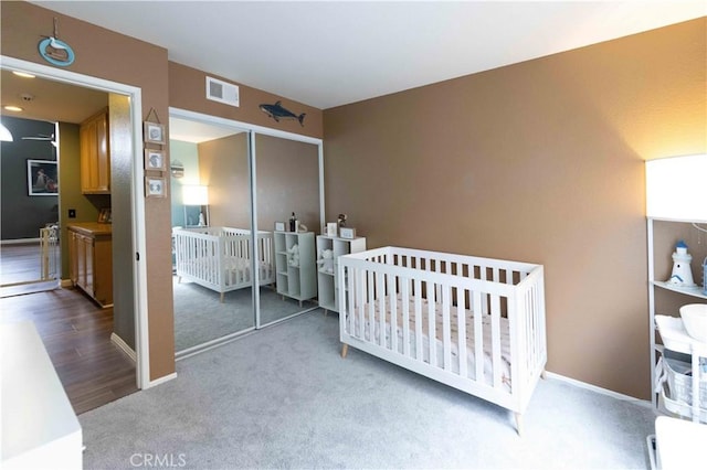 carpeted bedroom featuring baseboards, visible vents, and a closet