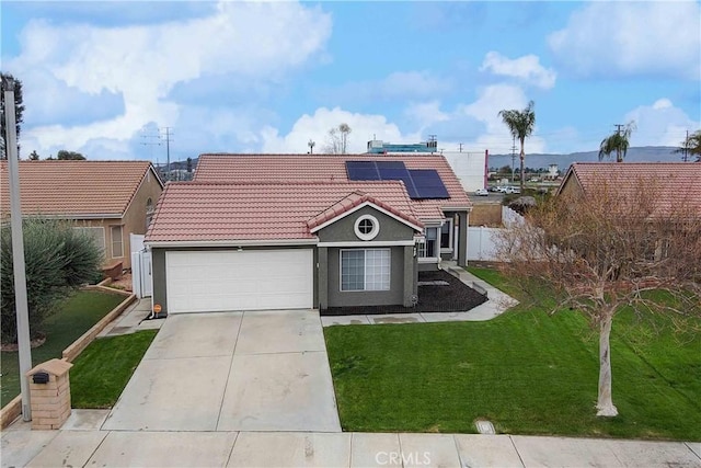 view of front of home with a front lawn, concrete driveway, a garage, solar panels, and a tiled roof