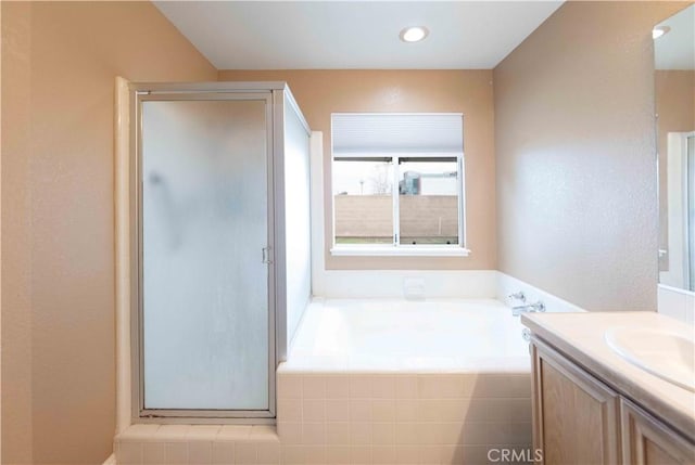 bathroom with recessed lighting, vanity, a bath, and a shower stall