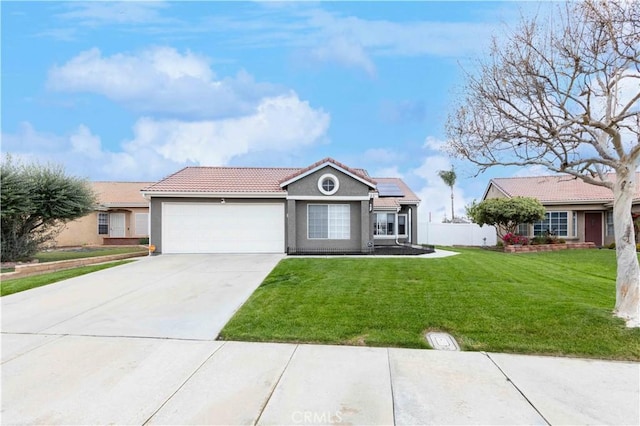 single story home with solar panels, a tiled roof, concrete driveway, a front yard, and a garage