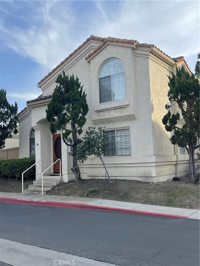 mediterranean / spanish-style home featuring stucco siding and a tile roof