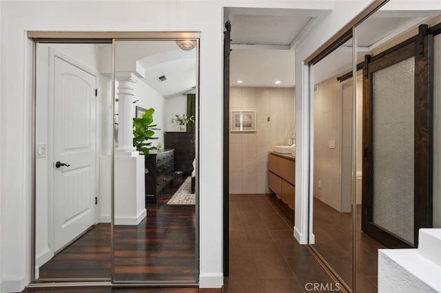 interior space featuring dark tile patterned floors, recessed lighting, and a barn door