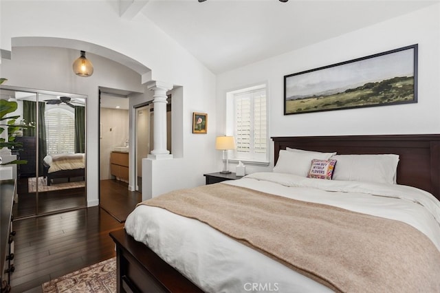 bedroom with vaulted ceiling with beams, dark wood-style floors, arched walkways, and ornate columns