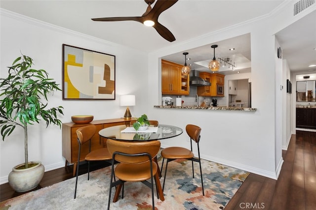 dining space with dark wood-style floors, visible vents, and ornamental molding