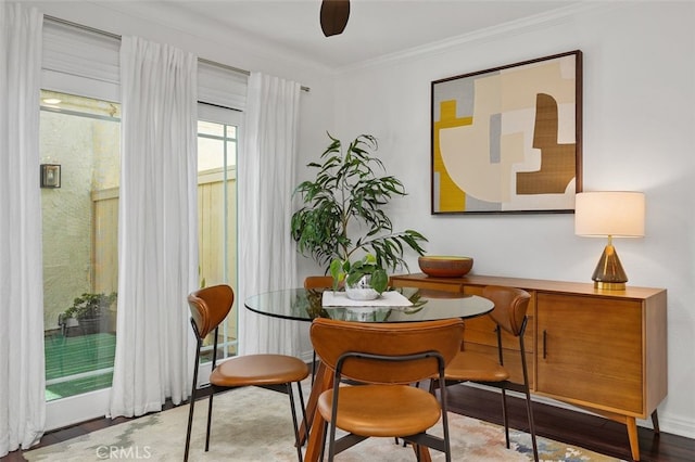 dining space with wood finished floors and ornamental molding