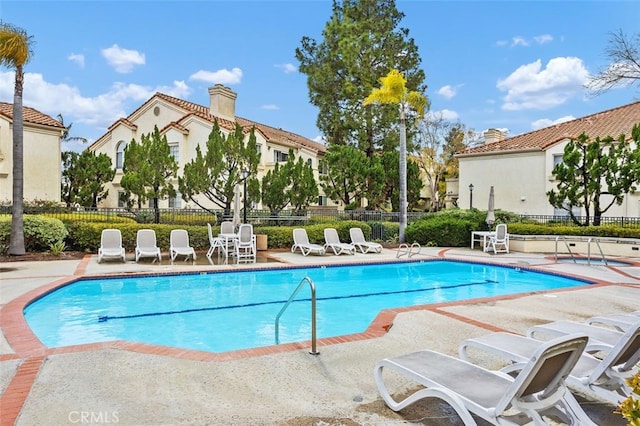 pool featuring a patio area and fence