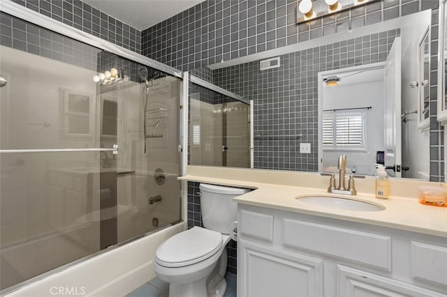 full bathroom featuring enclosed tub / shower combo, visible vents, toilet, and vanity