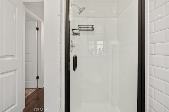 bathroom featuring wood finished floors and a stall shower