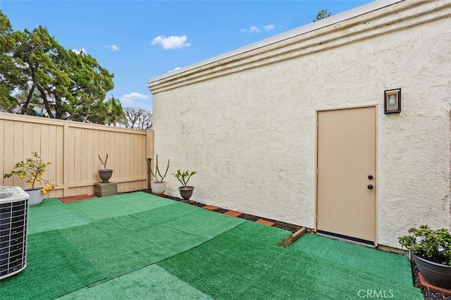 exterior space featuring central AC unit and a fenced backyard