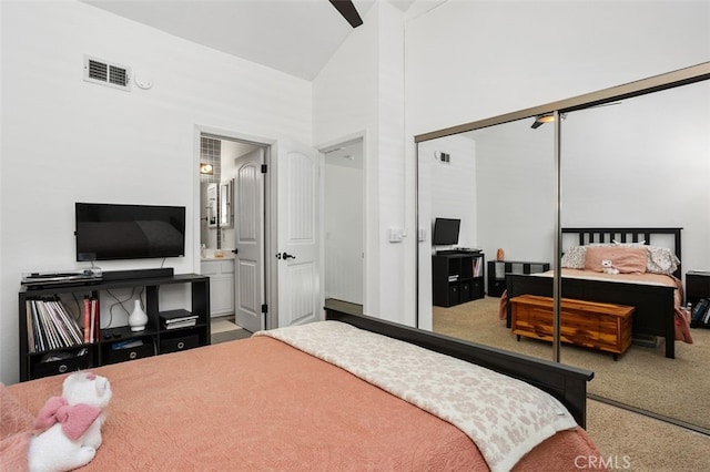 carpeted bedroom with ensuite bath, visible vents, a closet, and high vaulted ceiling