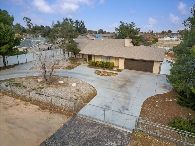 view of front facade featuring a fenced front yard, a garage, driveway, and a shingled roof