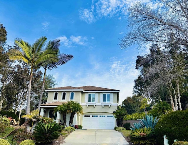 mediterranean / spanish home featuring stucco siding, an attached garage, and concrete driveway